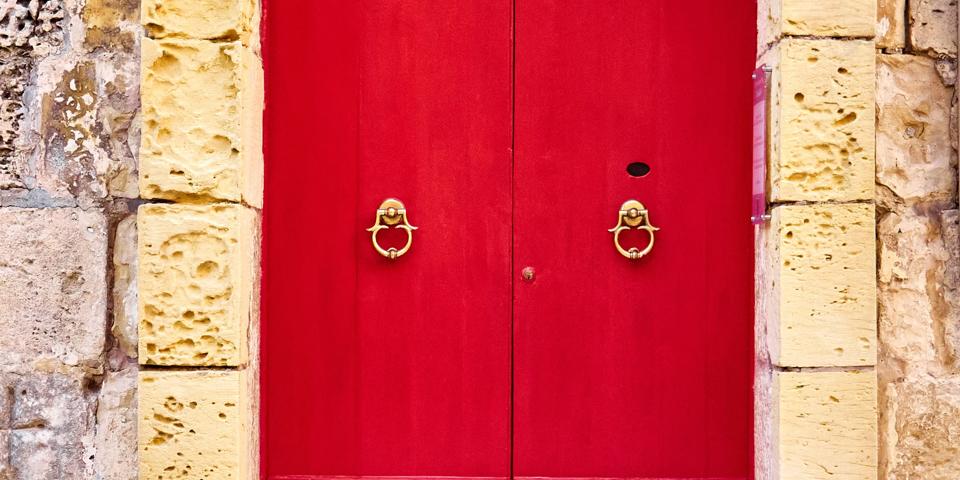 Red wooden door in the old town of Mdina, Malta