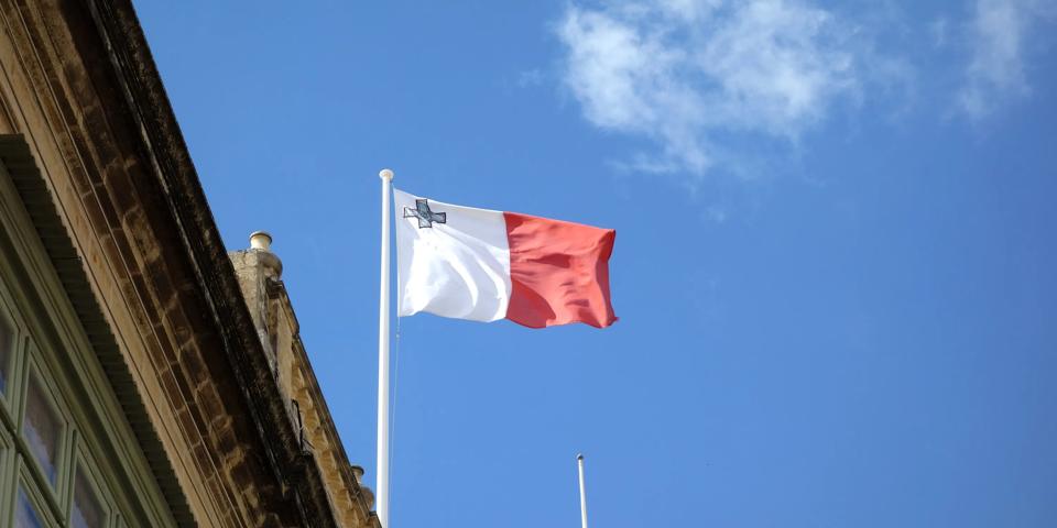 Flag of Malta, vertical bicolor of white and red with the representation of the George Cross edged in red on the upper hoist-side corner of the white band