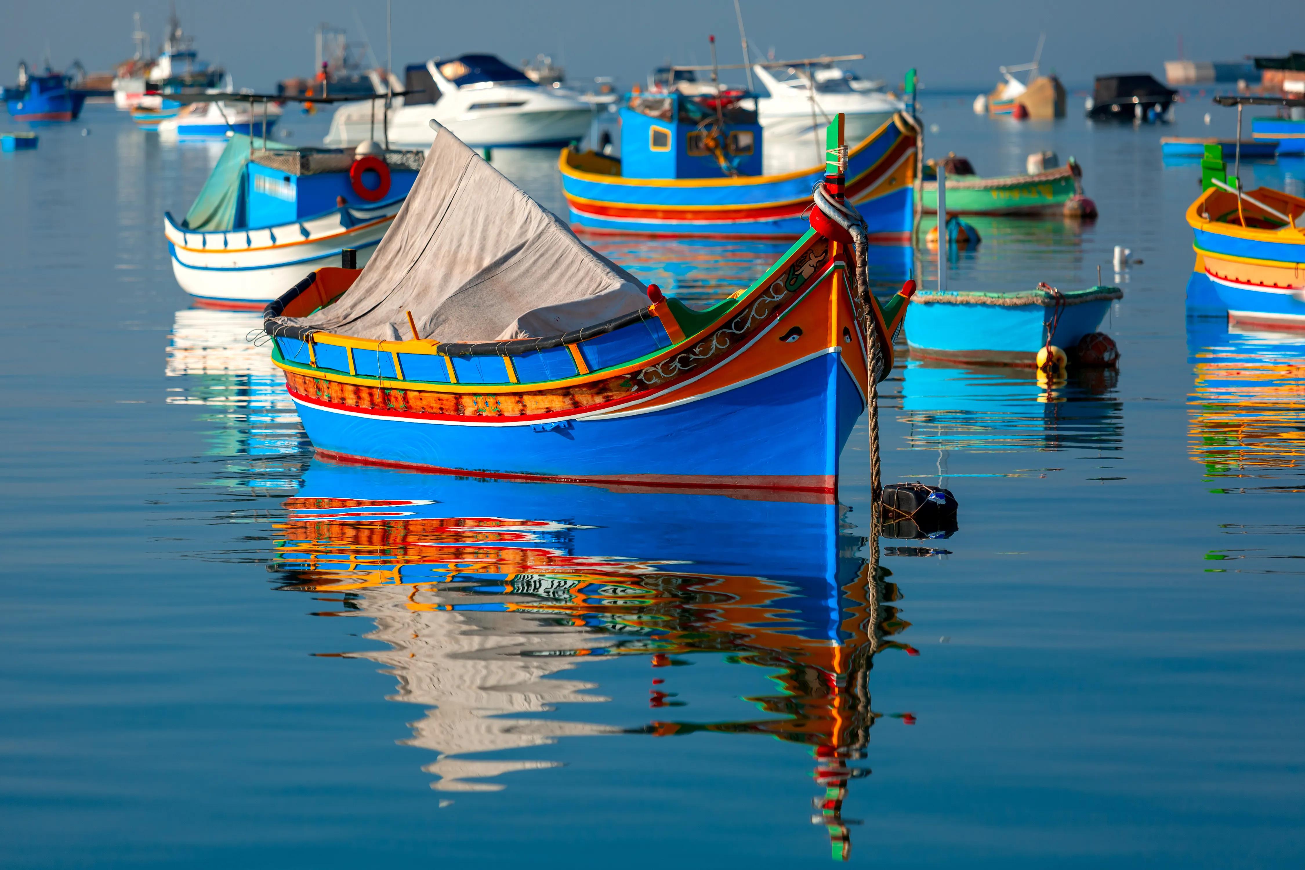 Traditional eyed colorful boats Luzzu in the Harbor of Mediterranean fishing village Marsaxlokk, Malta