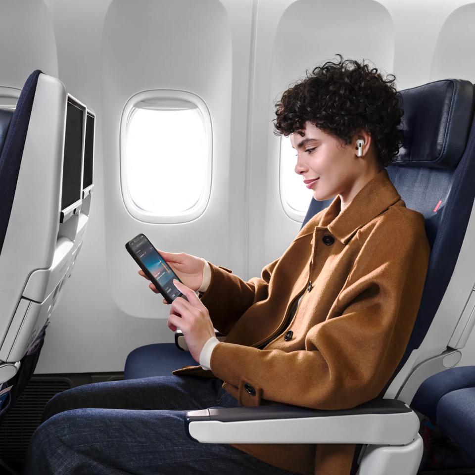 A young woman is peacefully enjoying the wifi while wearing her headphones